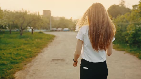 Portrait of a Coquettish Girl with Long Hair Turns Around Looking at the Camera