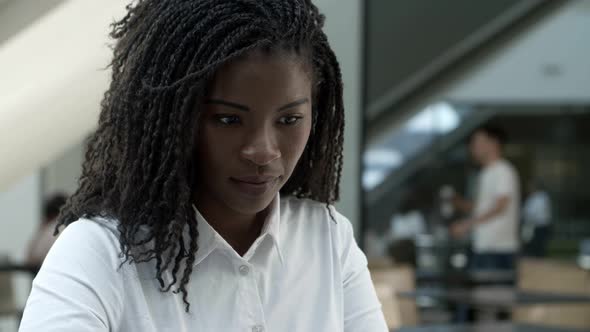 Cheerful Beautiful Young Woman with Dreadlocks Looking Down