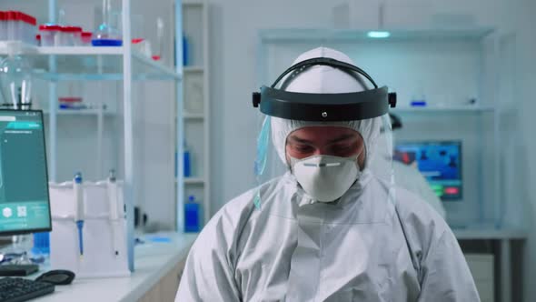 Portrait of Tired Scientist Man in Ppe Suit Looking at Camera