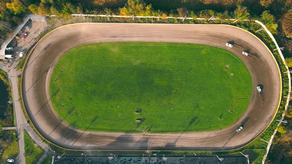 Aerial View on Top Races on the Racetrack. Cars Driving in a Circle Drifting Around Corners Compete