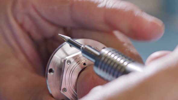 Close up on worker hands during metal part finishing process