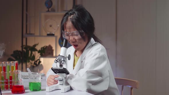 Excited Young Asian Scientist Girl With Dirty Face Looking At Microscope And Say Wow