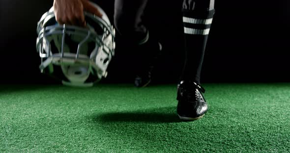 American football player resting his hands on head gear