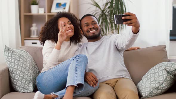 Happy Couple with Smartphone Taking Selfie at Home