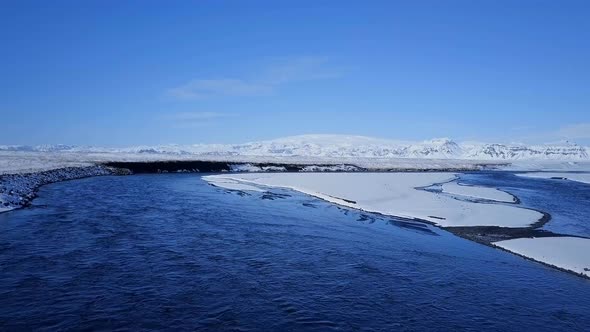 Aerial View of a Blue River in a Snowy Landscape