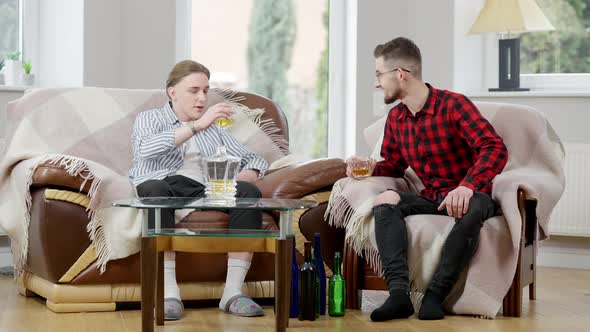 Wide Shot of Two Relaxed Caucasian Men Clinking Glasses and Talking Drinking Whiskey