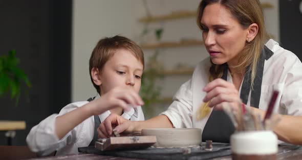 Mother and Son Boy Adorn a Clay Bowl with Letters Together