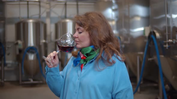 Female Sommelier Checking Wine Fermentation in Winery