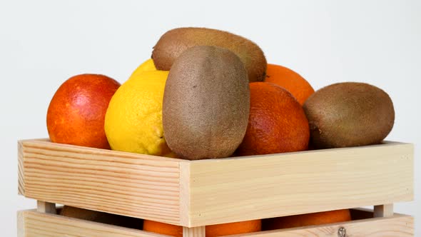 Fruits rotating in wooden box on white background