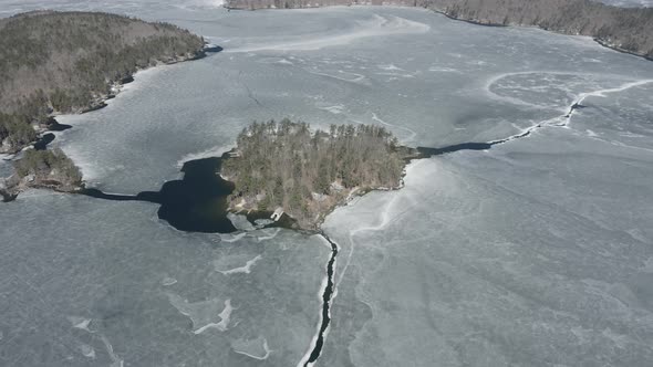 Drone shot of a big island, surrounded by frozen water.