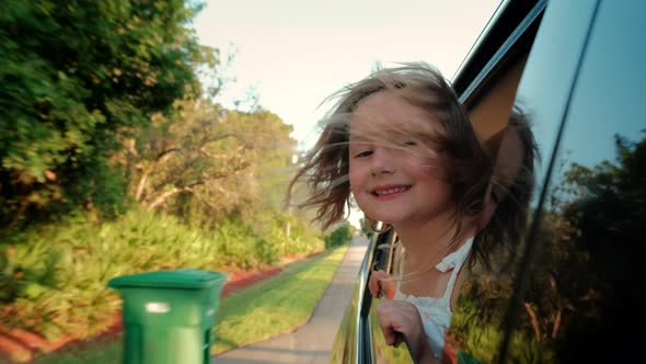 Teen Girl Ooking Out the Car Window and Waving His Hand