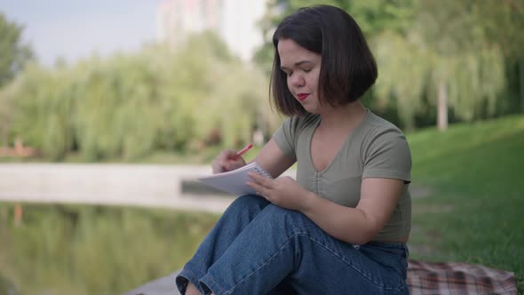 Side View Anxious Troubled Little Woman Writing Poems Sitting in Spring Park Making Mistake Tearing