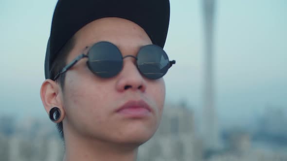 Slow motion close up shot of young asian photographer capturing skyline reflected in his sunglasses