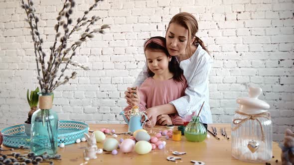 Little Girl and Mom Paints Eggs for Easter