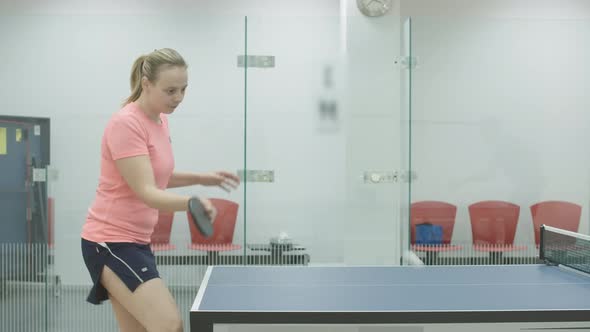 Side View of Confident Caucasian Woman in Sportswear Hitting Ball with Racket. Positive Young