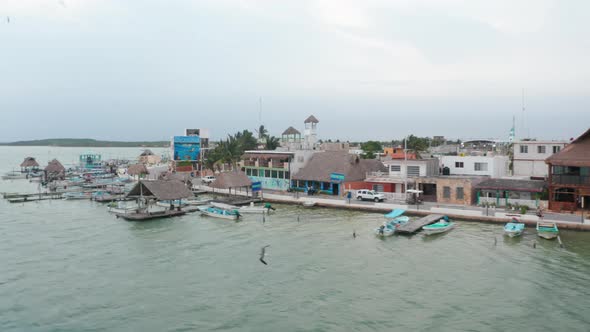 Aerial View of Lagoon Coastal Town with Many Small Boats and Low Buildings