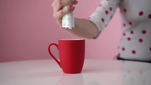 Sweetener falls into a cup in slow motion