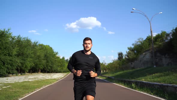 Athletic Young Man Running on the Road at Sunset