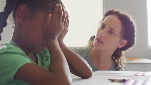 Video of caucasian female teacher supporting sad african american girl during lessons alt