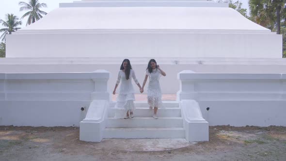 Two Asian Girls Holding Hand And Having Fun On Summer Travel Near The Temple