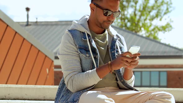 Man with Smartphone Drinking Coffee on Roof Top