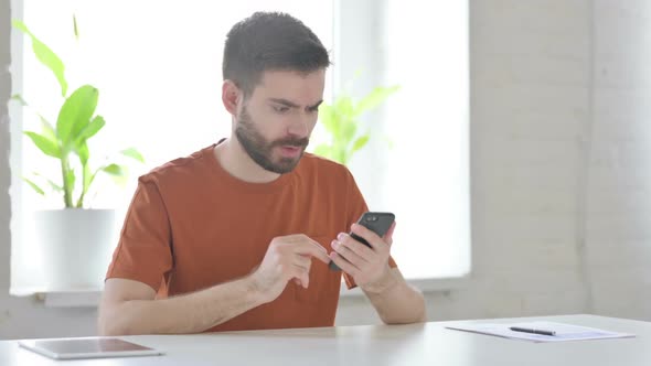 Upset Young Man Reacting to Loss on Smartphone