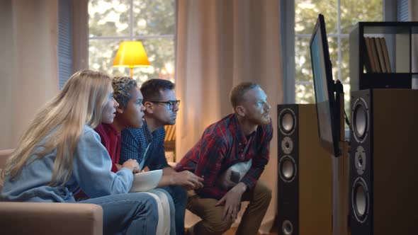 Side View of Diverse Friends with Popcorn Watching Tv at Home