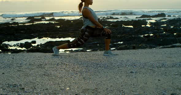 Woman exercising on beach at dusk 