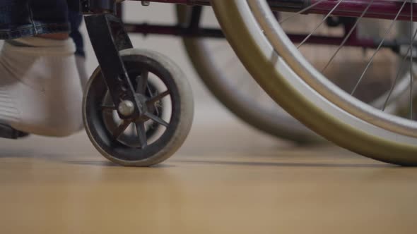 Side View Wheelchair with Disabled Man and Woman Pushing in Slow Motion