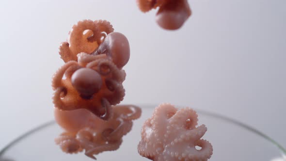 Camera follows cooking octopus in boiling water. Slow Motion.