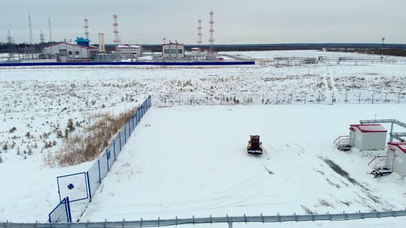 Clearing Snow with a Small Loader in the Taiga on the Oil and Gas Field