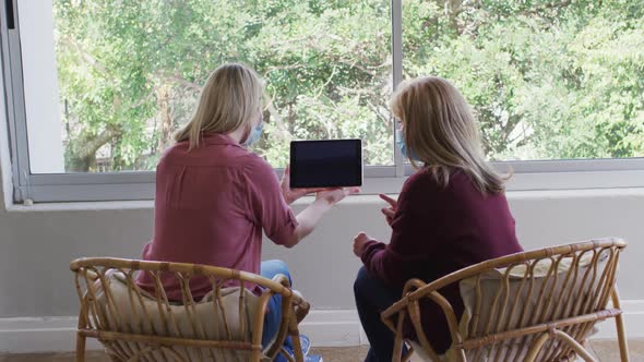 Mother and daughter using digital tablet at home