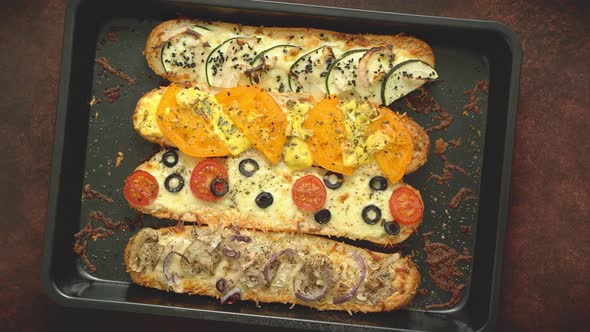 Delicious Hot Sandwich Baguettes Baked with Tuna, Cheese, Tomatoes, Olives, Courgette and Mushrooms