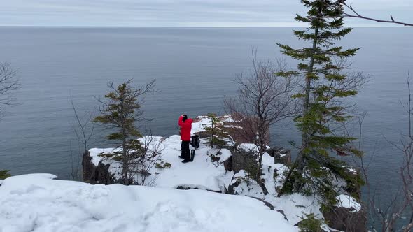 person looking to lake superior standing on a cliff in palisade head, minnesota state parks travel