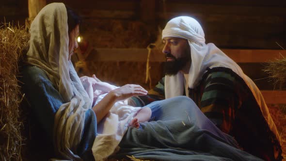 Mary and Joseph with Baby Jesus Resting in Dim Barn