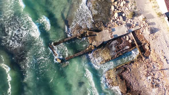 Coastal erosion at Trenc Beach in Mallorca Spain with damaged building foundation pounded by waves,