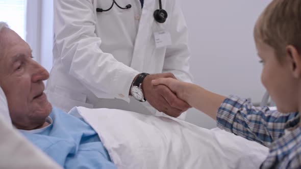 Doctor Shaking Hands with Little Grandson of Patient