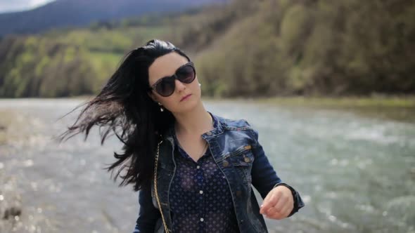 Brunette Posing for a Photo on Social Networks She Uses a Smartphone on a Background of Green Trees