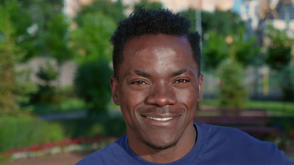 Close Up Smiling Afroamerican Man Looks Camera on Background Park in Summer