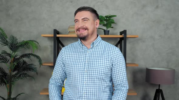 Portrait laughing bearded businessman standing in office turns head to camera