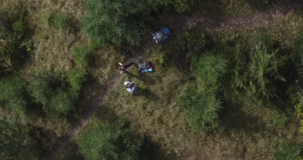 a guy with a girl tourists lower the drone to the ground and look up at the camera