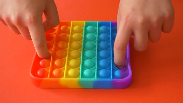 Child playing with rainbow pop it,top view.New antistress toy for children and adult