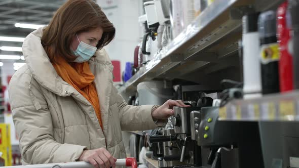 Woman Choosing Coffee Machine in Supermarket During Pandemic