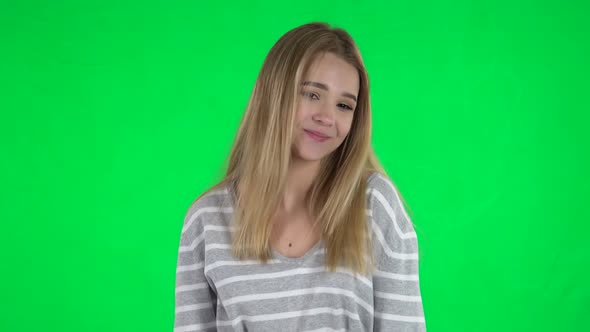 Portrait of Cute Blonde Girl with Long Hair Is Posing on a Green Screen
