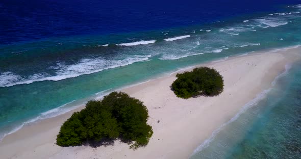 Daytime birds eye clean view of a sandy white paradise beach and blue sea background in 4K