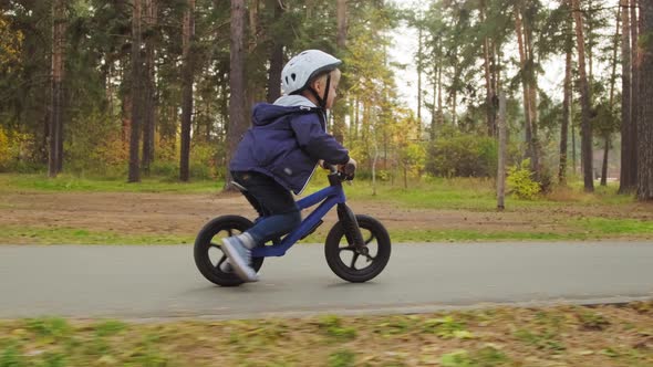 Cute Boy in Helmet Riding Balance Bike