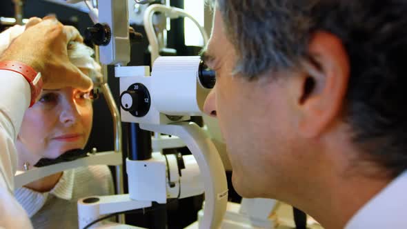 Optometrist examining patient eyes with slit lamp 4k