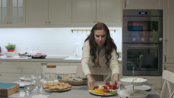 Woman Setting the Table for Family Celebration Dinner in the Kitchen