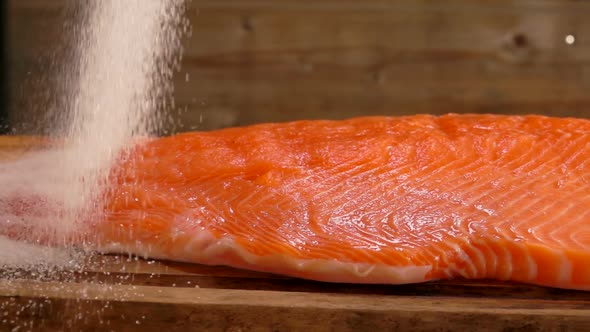 Salt Pours on Raw Salmon Fillet