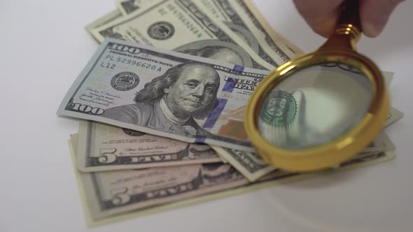 Checking American Dollars for Authenticity with a Magnifying Glass